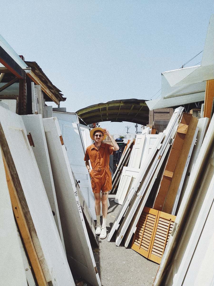 boat person standing beside white wooden panels dinghy
